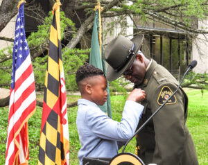 Col. Orlando Lilly is pinned by his son, wearing his Natural Resources Police badge for the first time at his swearing in ceremony. Maryland Department of Natural Resources photo.